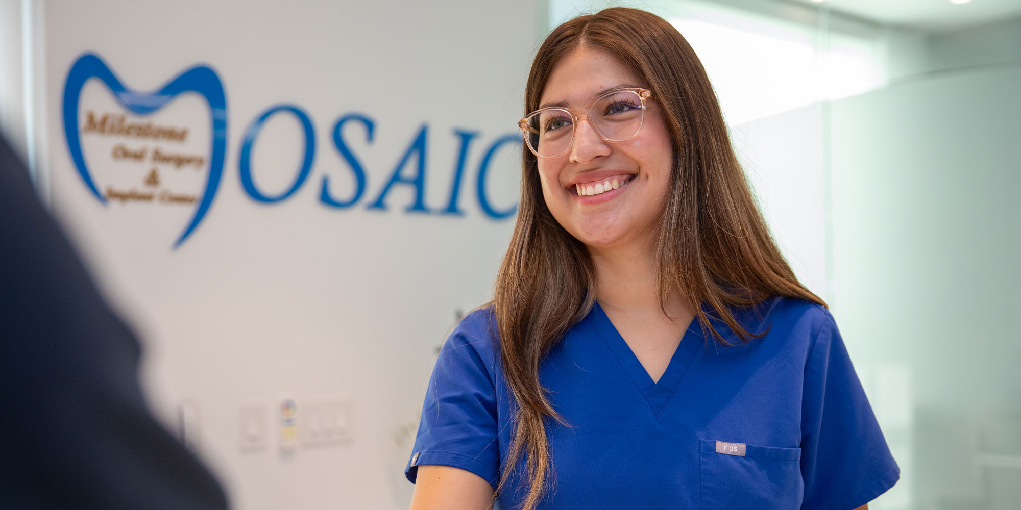 staff member helping patient at the front desk of the dental center