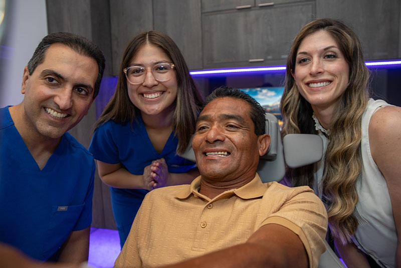 patient smiling brightly with staff members and doctor