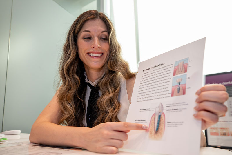 staff member going over dental implanr procedure information within the dental center