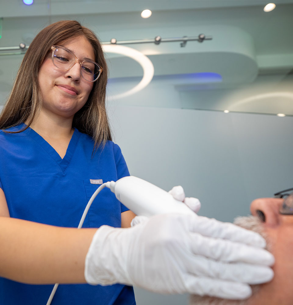 staff member performing examination on dental patient within the dental center